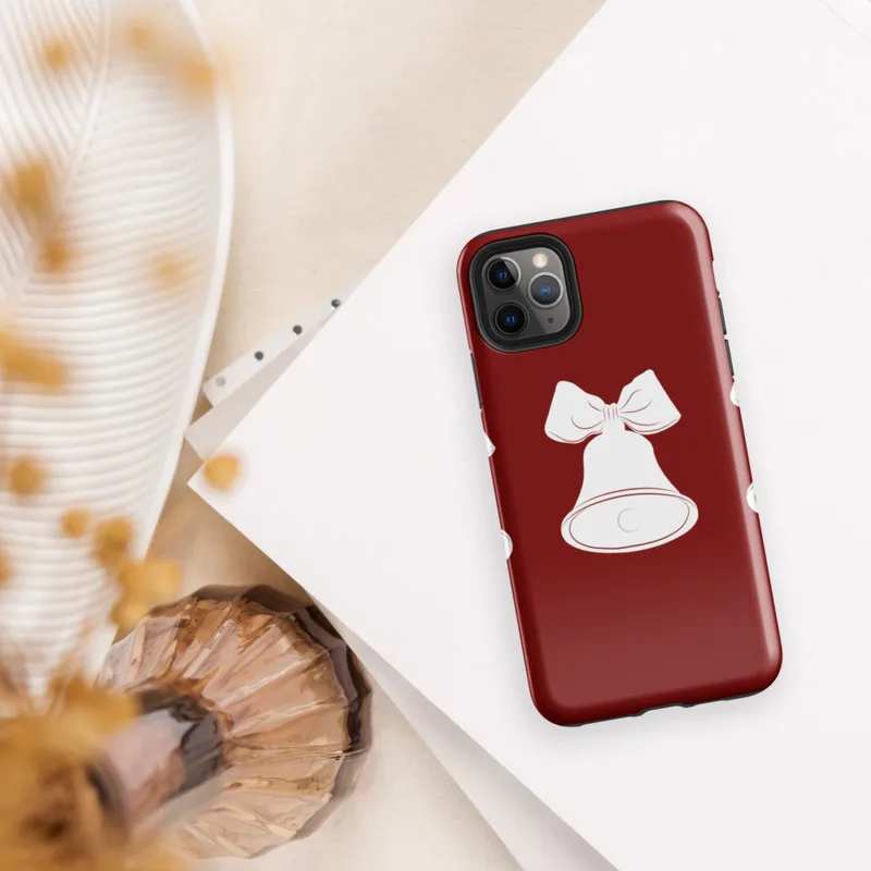 Glossy Jingle Bells Holiday Tough Case for iPhone — three white Christmas bells with ribbon bows arranged in a row on a deep
