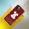 Glossy Jingle Bells Holiday Tough Case for iPhone — three white Christmas bells with ribbon bows arranged in a row on a deep
