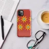 Glossy Solar Bloom Red Tough Case for iPhone — repeating pattern of yellow sunburst flowers with blue centers on a vivid red
