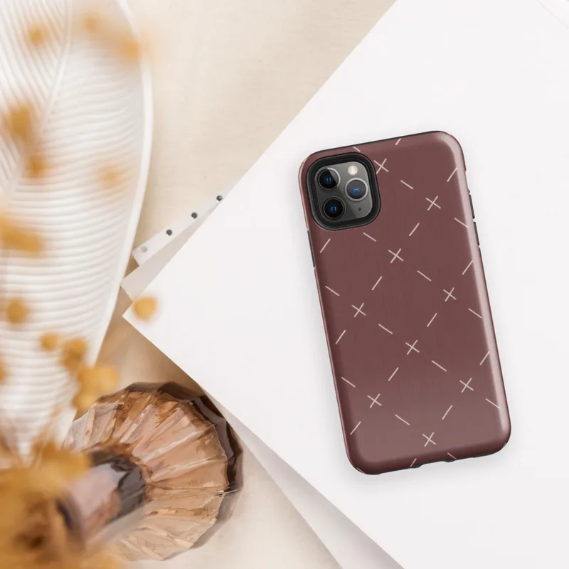 repeating ivory cross and dash marks scattered across a rich burgundy red textured background in a folk embroidery style on Glossy Crimson Cross Stitch Tough Case for iPhone - default view
