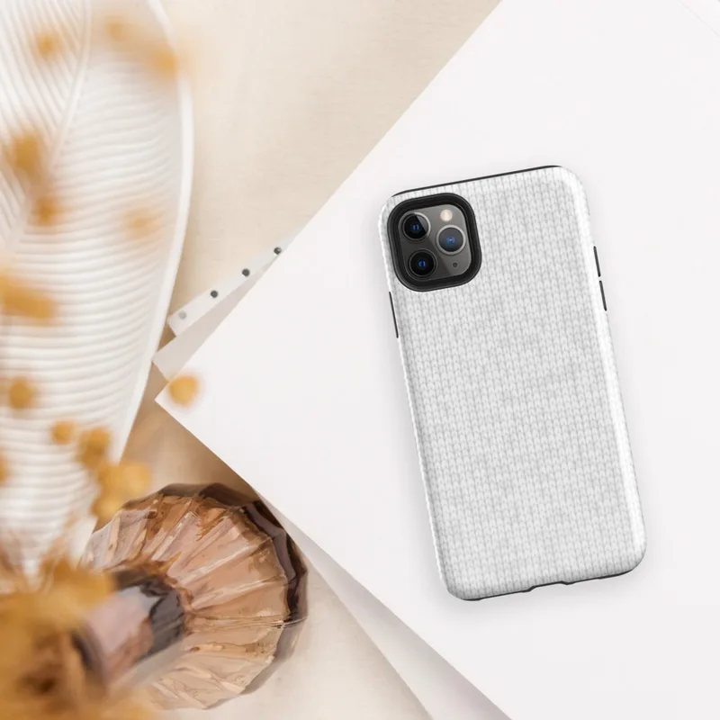 seamless white knit fabric texture with softly repeating tonal snowflake motifs in a light grey on white palette on Glossy Winter White Knit Texture Tough Case for iPhone - default view