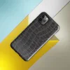 close-up black crocodile scale skin texture with raised interlocking rectangular scales and deep charcoal tones on Glossy Midnight Crocodile Armor Tough Case for iPhone - default view