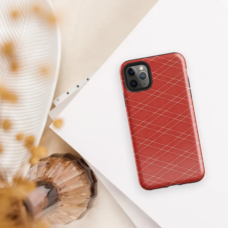 repeating cream-white diamond lattice grid over a deep crimson red textured background in a quilted isometric style on Glossy Scarlet Diamond Grid Tough Case for iPhone - default view